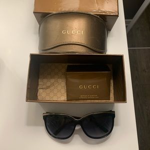 Gucci Oversized cat eye sunglasses with gold bar across the top.